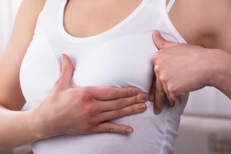 Regelmäßige Selbstkontrolle der Brust Frau tastet ihre Brust zur Selbstkontrolle ab